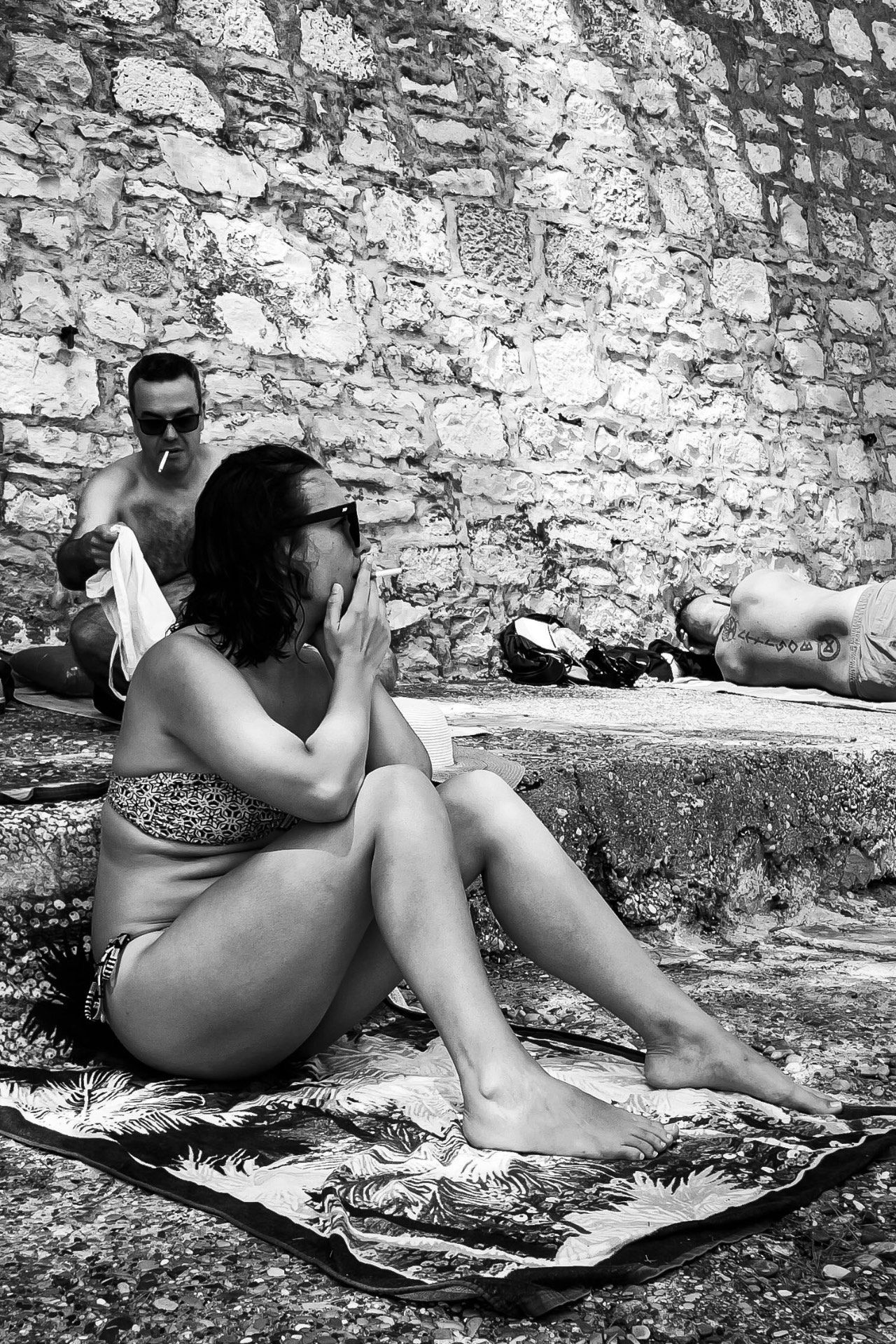 Sunbathers against a stone wall, Croatia